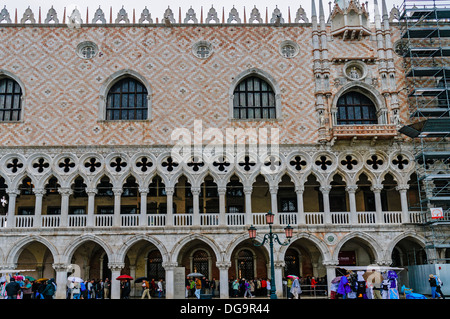 Attente des touristes dans l'arcade pour visiter l'intérieur du palais des Doges et d'éviter la pluie qui tombe sur la Piazzetta di San Marco Banque D'Images