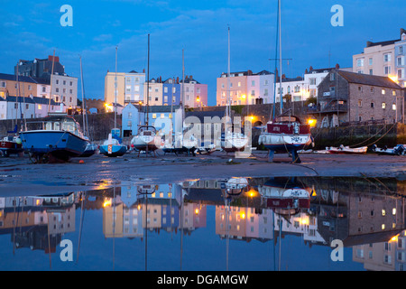 Port de Tenby au crépuscule avec la réflexion de bateaux et maisons en piscine de l'eau à marée basse Tenby, Pembrokeshire West Wales UK Banque D'Images