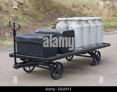 Vieux Métal Assurance des coffres et des bidons de lait sur chariot ferroviaire Banque D'Images