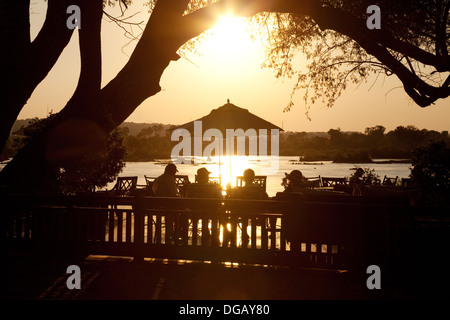 Invités sur le coucher du soleil terrasse en admirant le coucher du soleil sur le Zambèze, Royal Livingstone Hotel, Afrique Zambie Banque D'Images