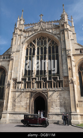 Une femme et un homme sortant de la cathédrale de Gloucester, Gloucester, Glous, UK. Banque D'Images