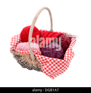 Rose, violet et rouge la laine à tricoter dans un panier, isolé sur fond blanc Banque D'Images