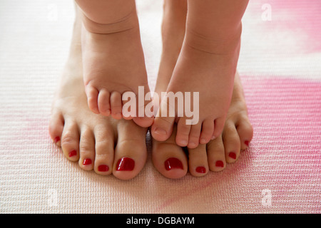 Les orteils de bébé sur les pieds de sa mère Banque D'Images