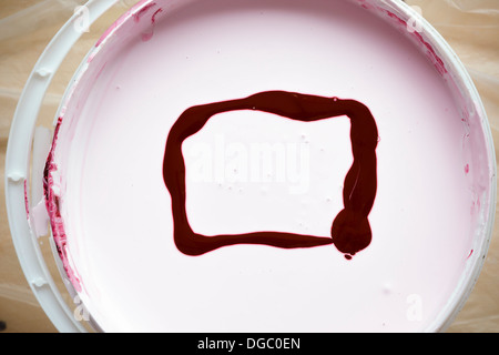 Seau avec peinture blanche avec châssis de couleur rouge Banque D'Images
