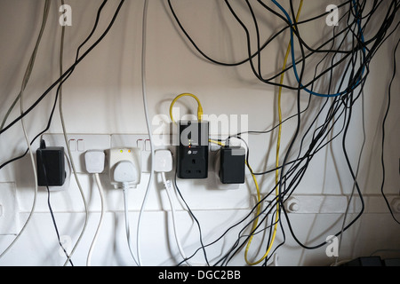 Un fouillis de câbles d'alimentation et les câbles de l'ordinateur sous un bureau Crédit photo : David Levenson / Alamy Banque D'Images