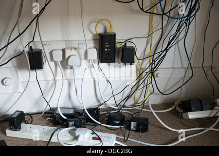 Un fouillis de câbles d'alimentation et les câbles de l'ordinateur sous un bureau Crédit photo : David Levenson / Alamy Banque D'Images