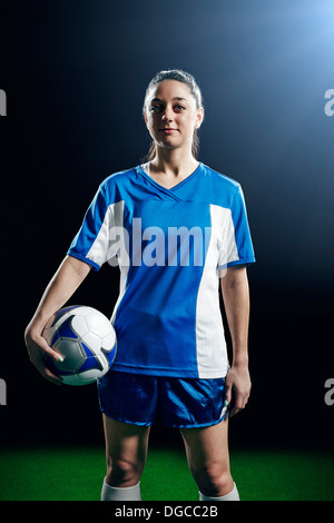 Portrait of female soccer player holding ball Banque D'Images