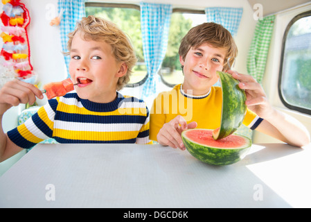 Les garçons eating watermelon en caravane, portrait Banque D'Images