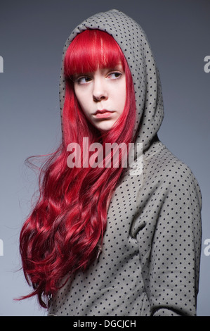 Jeune femme aux longs cheveux rouges en haut à capuchon Banque D'Images