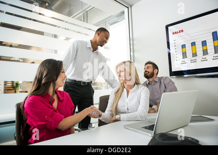 Young business colleagues shaking hands in conference room Banque D'Images