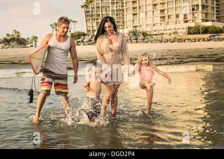Jeune famille pagayer dans l'eau Banque D'Images