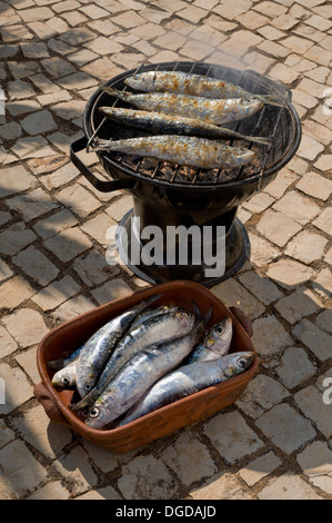 Le Portugal, l'Algarve, les sardines sur un grill rustique sur les galets dans la rue Banque D'Images