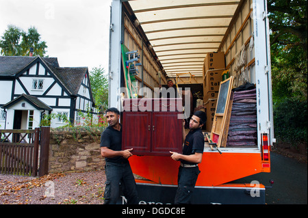 Déménageurs transportant dans un mobilier noir et blanc Cottage, Shropshire, Angleterre Banque D'Images