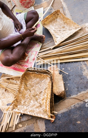 Faire de l'homme indien traditionnel tissé pelle du riz / Tamis de bambou dans un village de l'Inde rurale. L'Andhra Pradesh, Inde Banque D'Images