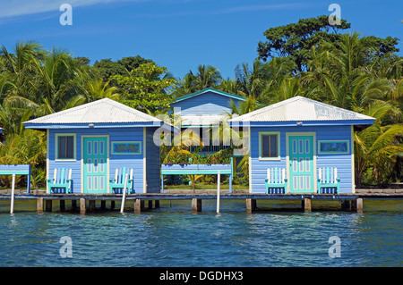 Bungalows sur pilotis avec des palmiers en arrière-plan, Bocas del Toro, mer des Caraïbes, l'Amérique centrale, le Panama Banque D'Images