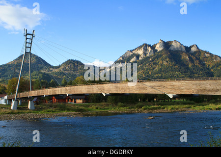 Sentier de suspension pont entre la Pologne et la Slovaquie sur la rivière Dunajec en montagnes Pieniny. Trzy Korony pic en arrière-plan. Banque D'Images