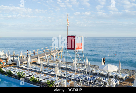 Chaises longues bordant la plage principale à Nice. Banque D'Images