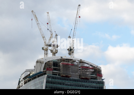 20 Fenchurch Street pendant la construction avec des grues à flèche relevable perché sur le toit inachevé Banque D'Images