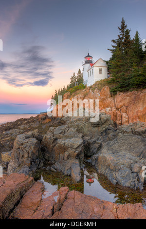 Le phare de Bass Harbor Head se reflète dans une piscine à marée peu avant le lever du soleil car il surplombe l'entrée de Bass Harbor dans le parc national Acadia. Banque D'Images