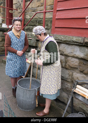 Deux femmes habillées en habits d'époque montrant le lavage à Goathland durant la guerre en fer week-end Octobre 2013 Banque D'Images