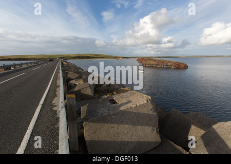 Des îles Orcades, en Écosse. L'A961 à barrière Churchill numéro 3 avec un blockship engloutie dans l'arrière-plan. Banque D'Images