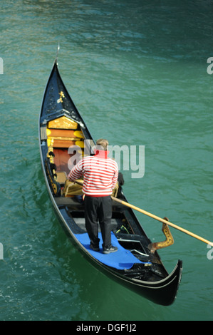 Un gondolier voyageant sur le Grand Canal à Venise en Italie. Banque D'Images