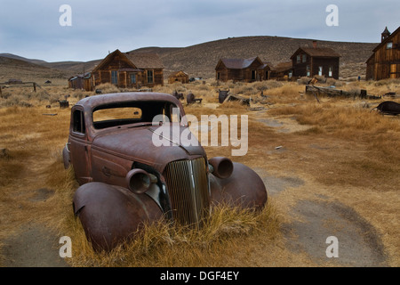 Old rusted voitures en champ, Bodie State Historic Park, comté de Mono, en Californie Banque D'Images