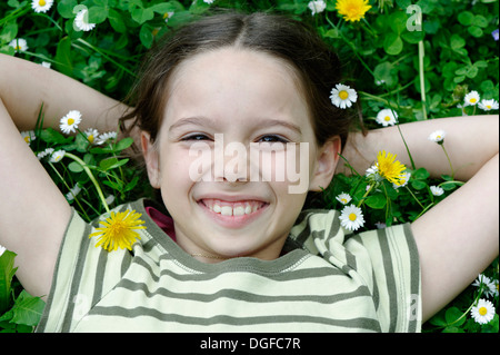 Girl lying on a flower meadow, Upper Bavaria, Bavaria, Germany Banque D'Images