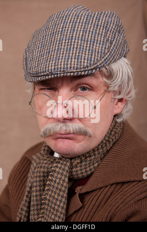 Portrait d'un vieil homme aux cheveux gris portant le chapeau et l'écharpe télévision confortable, contre un fond brun. Banque D'Images