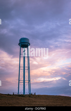 Tour de l'eau sur une colline contre un ciel mauve au coucher du soleil Banque D'Images