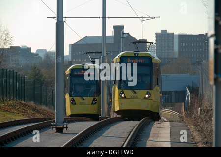 Deux tramways Metrolink près du campus d'Etihad de tram, sur la ligne East Manchester Eastlands,, Manchester, Angleterre, RU Banque D'Images