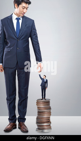 Un business man holding un géant business mans hand Banque D'Images