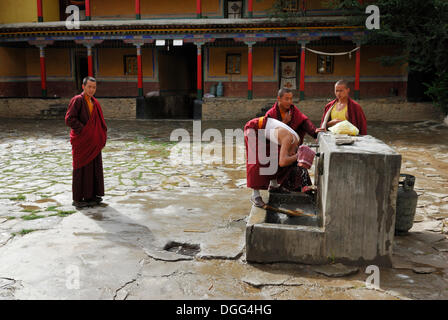 Les jeunes moines tibétains pendant leur toilette matinale dans la cour du monastère de Mindroling, Luzhou, Tibet, Chine, Asie Banque D'Images