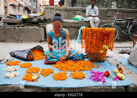 Femme fabriquer et vendre des colliers de fleurs, Katmandou, Népal, Asie Banque D'Images