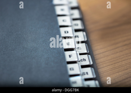 Sur un registre alphabétique dossier noir sur une table en bois, faible profondeur de champ Banque D'Images