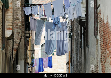 Étroitement construit des maisons, lave accroché sur les lignes de lavage s'étendait sur une allée, Castello, Venise, Venise, Vénétie, Italie, Europe Banque D'Images