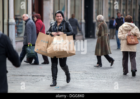 Une femme shopper promenades à travers le centre-ville de Liverpool transportant Primark shopping bags Banque D'Images