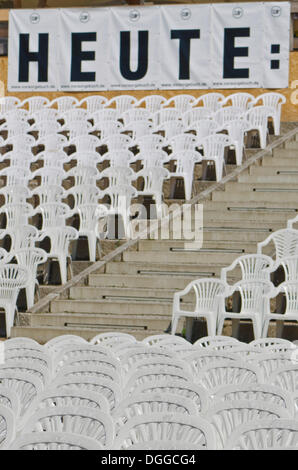 Panneau "heute", l'allemand pour "aujourd'hui", et des chaises en plastique blanc disposés en rangées à un concert en plein air, Dresden Banque D'Images