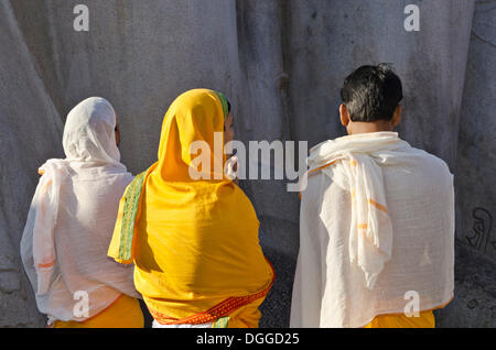 Jain pèlerins récitant des textes religieux au pied de la gigantesque statue de Gomateshwara à Sravanabelagola, Inde, Asie Banque D'Images