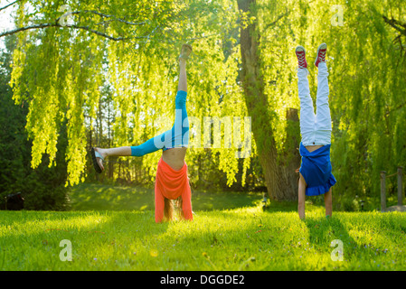 Deux filles faisant handstands in park Banque D'Images