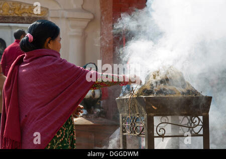 La femme en face de l'encense herbal gravure Boudnath Stupa, Vallée de Katmandou, Katmandou, Katmandou, Népal, Zone Bagmati Banque D'Images