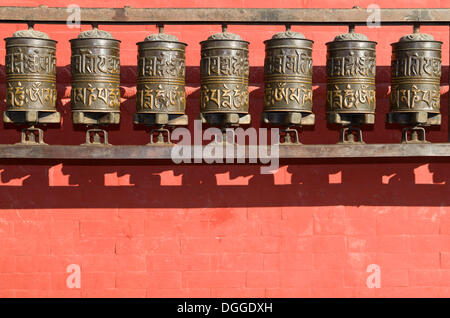 Roues de prière bouddhiste en face d'un mur rouge à Swayambhunath Stupa, Monkey Temple, Vallée de Katmandou, Katmandou Banque D'Images