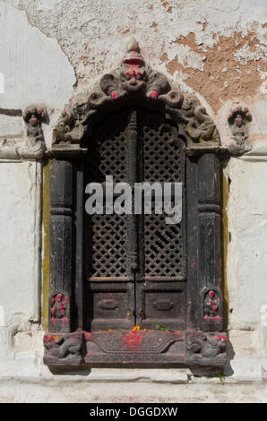 Fenêtre en bois sculpté orné d'un petit sanctuaire dans les collines au-dessus du temple de Pashupatinath, Katmandou, district de Katmandou Banque D'Images