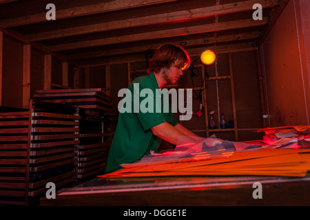 L'homme travaillant dans l'atelier de sérigraphie en chambre noire Banque D'Images