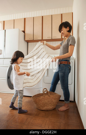 Mother and Daughter folding towel Banque D'Images