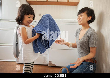 Mère et fille, girl folding towel Banque D'Images