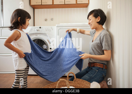 Mother and Daughter folding towel Banque D'Images