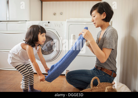 Mother and Daughter folding towel Banque D'Images