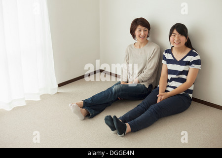 Mère et fille adolescente sitting on floor, portrait Banque D'Images