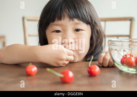 Girl eating cherries, portrait Banque D'Images